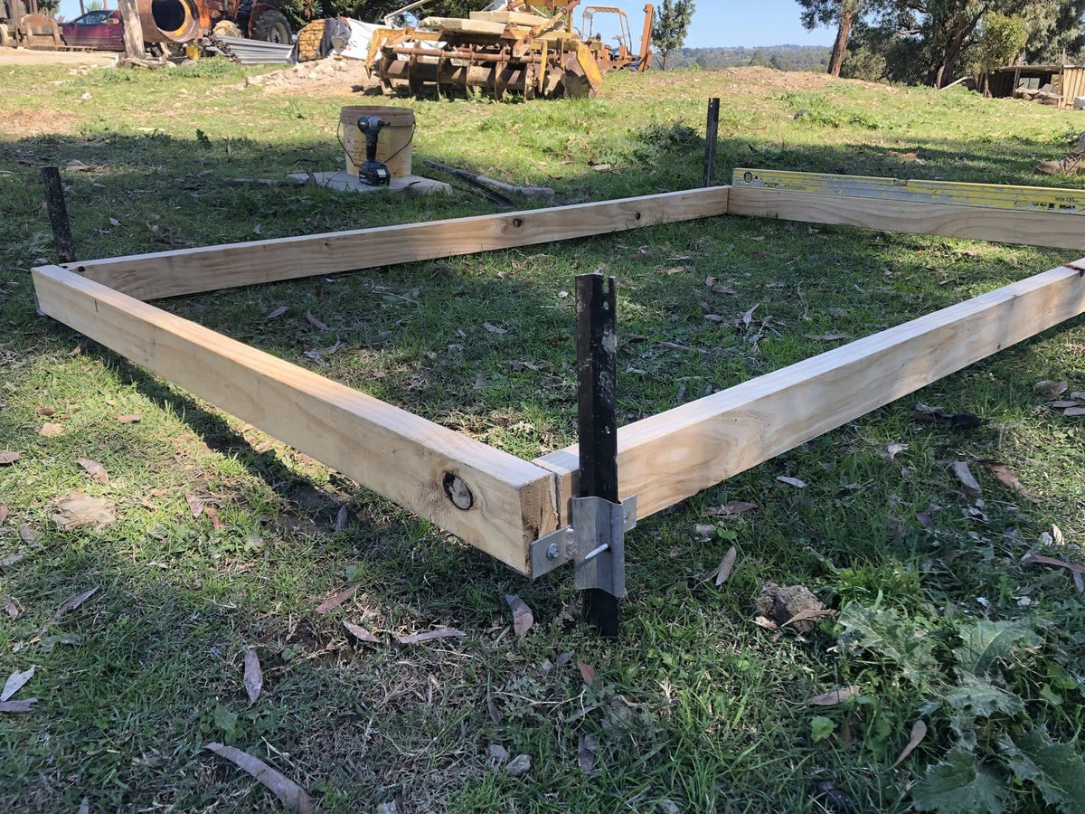 StakeTek flat bracket clamping a timber boxing frame to a star picket